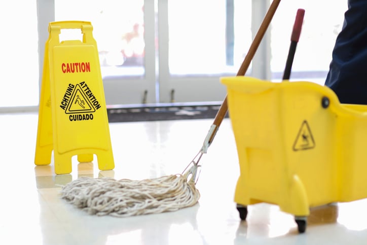 janitor using mop and bucket on floor